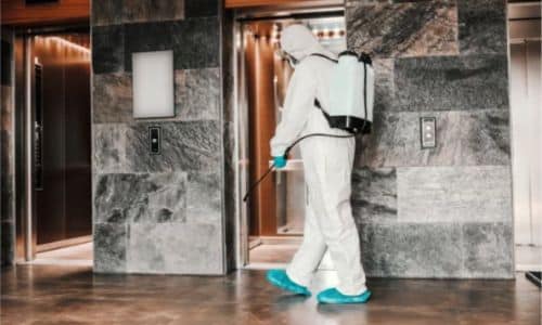 specialista effettua la disinfezione negli hotel, passano i prodotti vicino agli ascensori